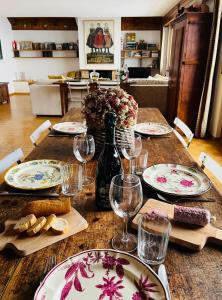 a wooden table with plates and wine glasses on it at tHE Eagle Nest Duplex - Your Mountain Retreat in Chalais