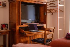 a room with a desk with a laptop and a television at Les Balcons sur la Loire in Chalonnes-sur-Loire