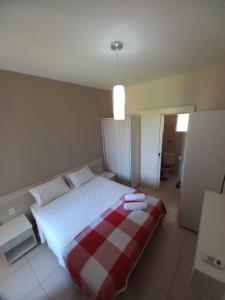 a bedroom with a bed with a red and white blanket at Cumbuco Residence - Beach in Cumbuco +13 photos