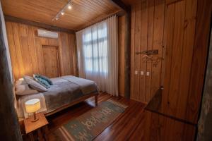 Un dormitorio con una cama y una ventana y paredes de madera. en Monã, en Canela