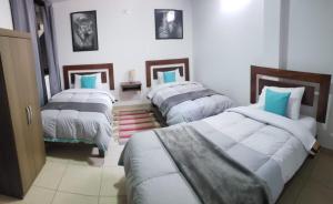 Un grupo de 4 camas en una habitación en Samuel's House, en Machu Picchu