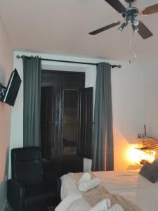 um quarto com uma cama e uma cadeira e uma ventoinha de tecto em Supl. 22 Cabernet em Novelda