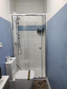uma casa de banho com um WC e uma cabina de duche em vidro. em Supl. 22 Cabernet em Novelda