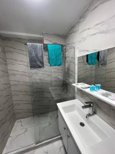 a bathroom with a sink and a shower with blue towels at Hotel Peak in Gudauri