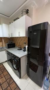 La cuisine est équipée d'un réfrigérateur noir et d'un lave-vaisselle. dans l'établissement Well-furnished apartment i Agadir!, à Agadir
