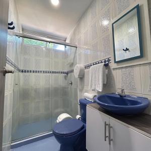 a bathroom with a blue toilet and a shower at Hotel Sun Suite in Barranquilla