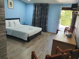 アルママールにあるGojim Casa Ruralのベッドルーム1室(青い壁のベッド1台、デスク付)