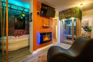 sala de estar con chimenea y bañera en Le Lovely Gruissanais - Balneo & Sauna, en Gruissan