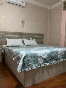 ein Schlafzimmer mit einem Bett mit einer Decke darauf in der Unterkunft Pamir Hotel-Hostel in Duschanbe