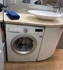 une machine à laver sous un comptoir avec un évier dans l'établissement Apartament Blisko Centrum, à Kielce 15 autres photos