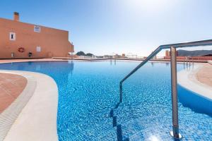 a swimming pool with blue water in front of a building at Miratlántico, Águilas del Teide. in Chayofa