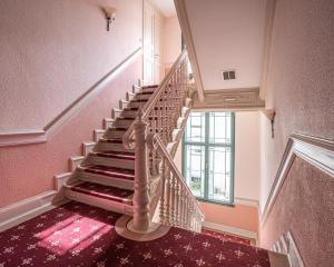 a staircase in a house with pink walls at Appartement mit kleiner Veranda in Heringsdorf +6 photos
