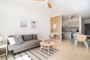 a living room with a couch and a table and a kitchen at Miratlántico, Águilas del Teide. in Chayofa