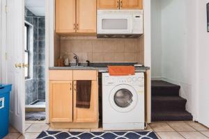 a kitchen with a washing machine and a microwave at East Village Townhouse in New York