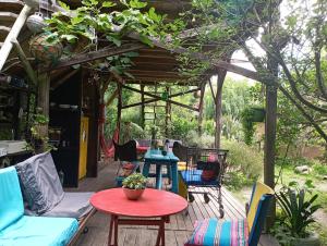 um pátio com uma mesa e cadeiras num deque em Nature Hostel em Barra de Valizas