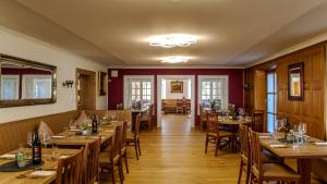 uma sala de jantar com mesas e cadeiras de madeira em Allgäu Residenz Natur & Spa GmbH em Wiggensbach