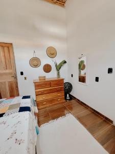 a bedroom with a bed and a wooden dresser at Casa Mar in Caraíva