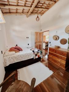a bedroom with a bed and a wooden floor at Casa Mar in Caraíva