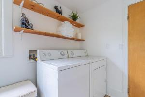a white laundry room with a washer and dryer at Capitol Hill Cutie in Seattle