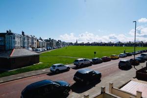 eine Gruppe von Autos, die auf einem Parkplatz geparkt sind in der Unterkunft Longsands Beach, Apartment 2, Tynemouth in Tynemouth