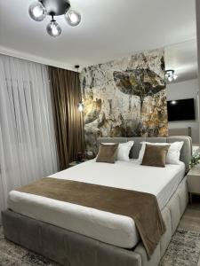 a bedroom with a large bed and a stone wall at Est One Apartament 2 camere semidecomandat in Drobeta-Turnu Severin