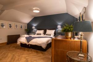 a bedroom with a bed and a table and a lamp at The Brasenose Arms in Banbury