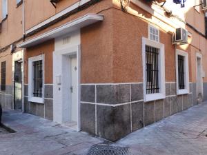 a brick building with barred windows on a street at Plan B Madrid Vallecas in Madrid