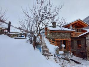 a snow covered log cabin with a snow covered yard at CasAlpAca B&B con sauna a Prali in Prali