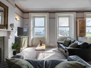 uma sala de estar com um sofá e uma televisão em Longsands Beach, Apartment 2, Tynemouth em Tynemouth