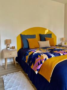 a bedroom with a bed with a colorful bedspread at Le moulin du Mesnil in Saint-Georges-sur-Cher