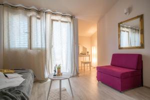 ein Schlafzimmer mit einem lila Stuhl und einem Tisch in der Unterkunft Apartments Sonata in Omiš