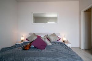 ein Schlafzimmer mit einem Bett mit Violine drauf in der Unterkunft Apartments Sonata in Omiš