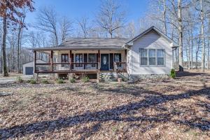 a small house with a porch on a yard at Clarksville Home with Porch and Fishing Pond Access! in Clarksville