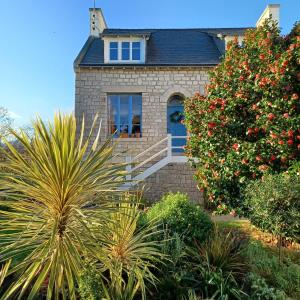 uma casa de pedra com uma janela e uma árvore em Le Banellou em Quimper