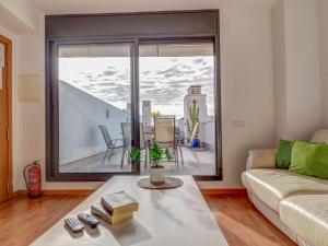 ein Wohnzimmer mit Couch und großem Fenster in der Unterkunft Mimosa Apartment by Hello Homes Sitges in Sitges