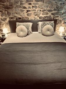 een slaapkamer met een bed met 2 kussens erop bij L AUBERGE DE l Entre Potes Scandinavia in Aat