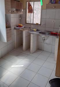 a kitchen with white tiled floors and a sink at Kitnet recife carnaval 2024 in Recife