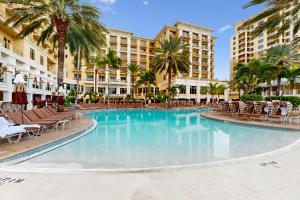 een zwembad in het resort met stoelen en palmbomen bij Sandpearl unit 757 in Clearwater Beach
