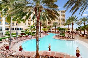 a pool at the resort with chairs and palm trees at Sandpearl unit 757 in Clearwater Beach