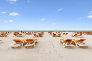 a group of chairs and lounge chairs on a beach at Sandpearl unit 757 in Clearwater Beach
