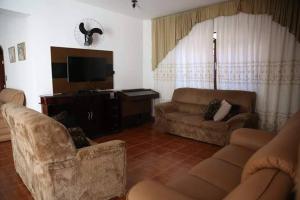 a living room with two couches and a flat screen tv at Casa em Águas de Lindóia in Águas de Lindóia