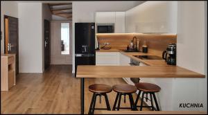 a kitchen with a wooden counter and stools in it at Spokojna Sosnówka in Sosnówka