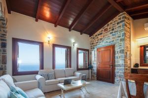 a living room with a couch and a stone wall at Villa Ligaria, Lygaria in Agia Pelagia