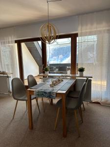 a dining room table with chairs and a chandelier at Bollenlodge - Ferienwohnung mit Ausblick und Top Lage in Todtnau