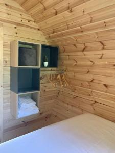 um quarto com uma parede de madeira e uma televisão em A Chjusella di E Sertine em Tralonca