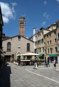 un edificio con una torre dell'orologio su una strada cittadina di San Tomà a Venezia