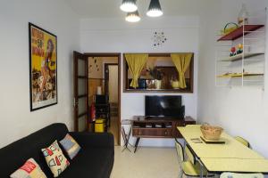 een woonkamer met een bank en een tafel bij Casa da Fonte - Vintage House and Rooftop in Figueira da Foz