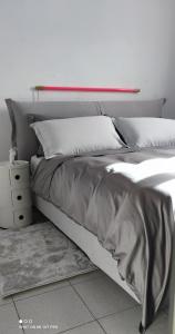 1 cama con sábanas de plata y almohadas en un dormitorio en B&B Al 27, en Paderno dʼAdda
