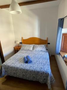 a bedroom with a bed with two blue pillows on it at La magnolia in La Puerta de Segura