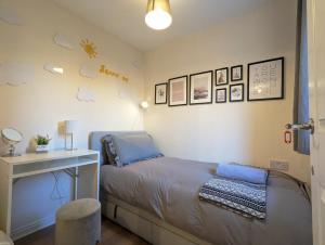 a bedroom with a bed with a desk and pictures on the wall at Guest Rooms Near City Centre Anfield Free Parking in Liverpool